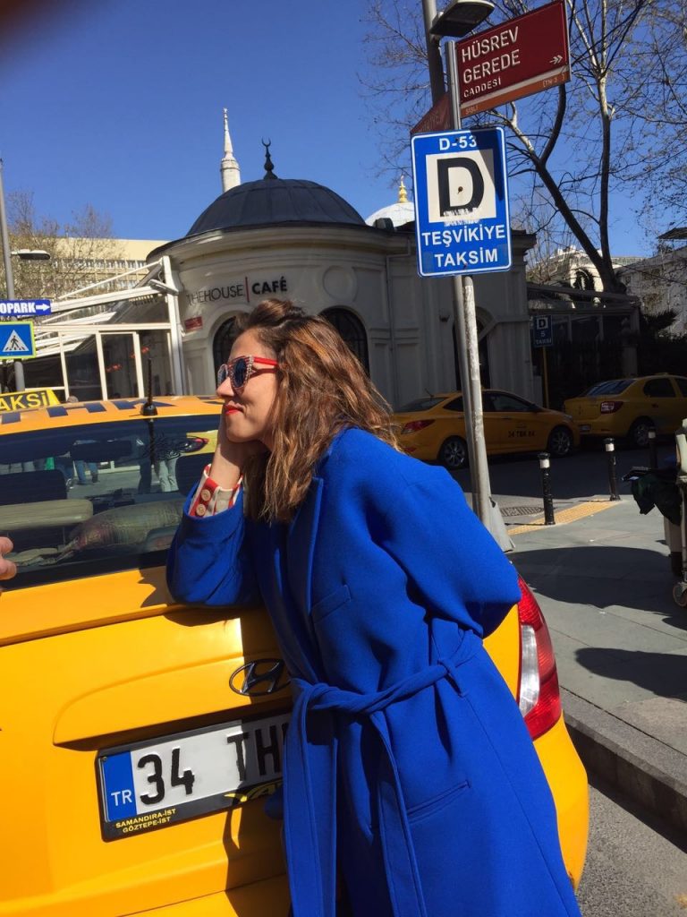 Mavi paltolu kadın İstanbul Teşvikiye'de sarı taksiye yaslanmış