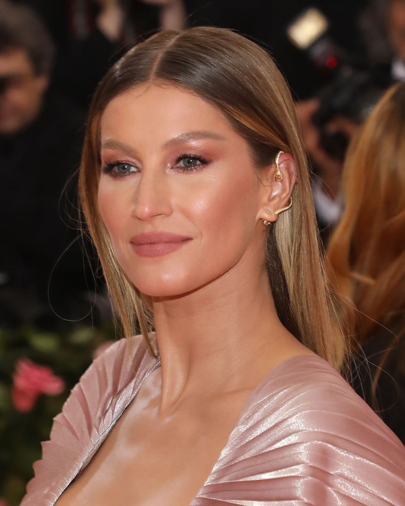 Gisele Bündchen pembe elbiseyle yılan küpeli gülümseyen zarif bir portre