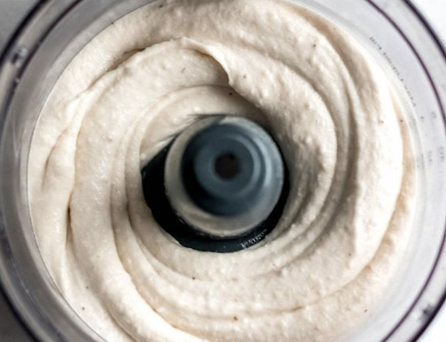 Mutfak robotunda dönen açık renkli kremalı yiyecek karışımı