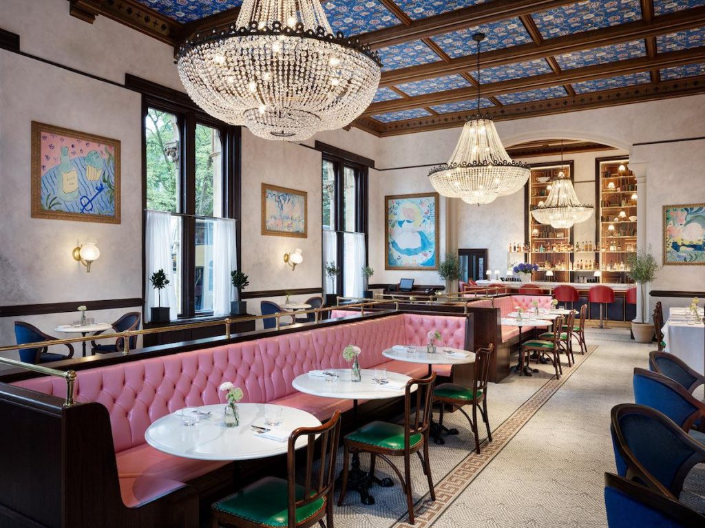 Gösterişli avizeler pembe banketler ve desenli mavi tavanlı lüks restoran