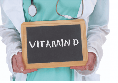 Bir doktor elinde VİTAMİN D yazılı kara tahta tutuyor