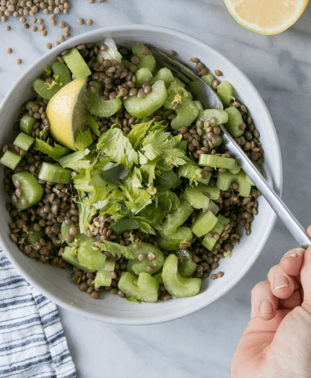Doğranmış kereviz, mercimek, limon ve yeşilliklerle dolu salata kasesi