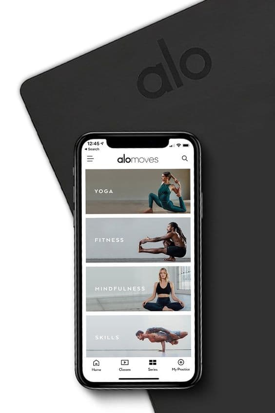 Siyah yoga matı üzerinde Alo Moves uygulaması gösteren iPhone