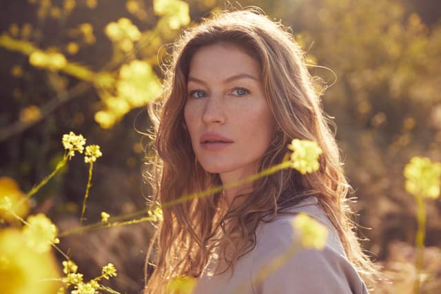 Güneşli sarı çiçekler arasında Gisele Bündchen'in doğal güzelliği