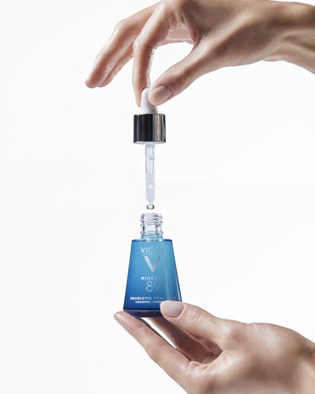 Vichy Mineral 89 serum şişesi ve damlalığı tutan eller