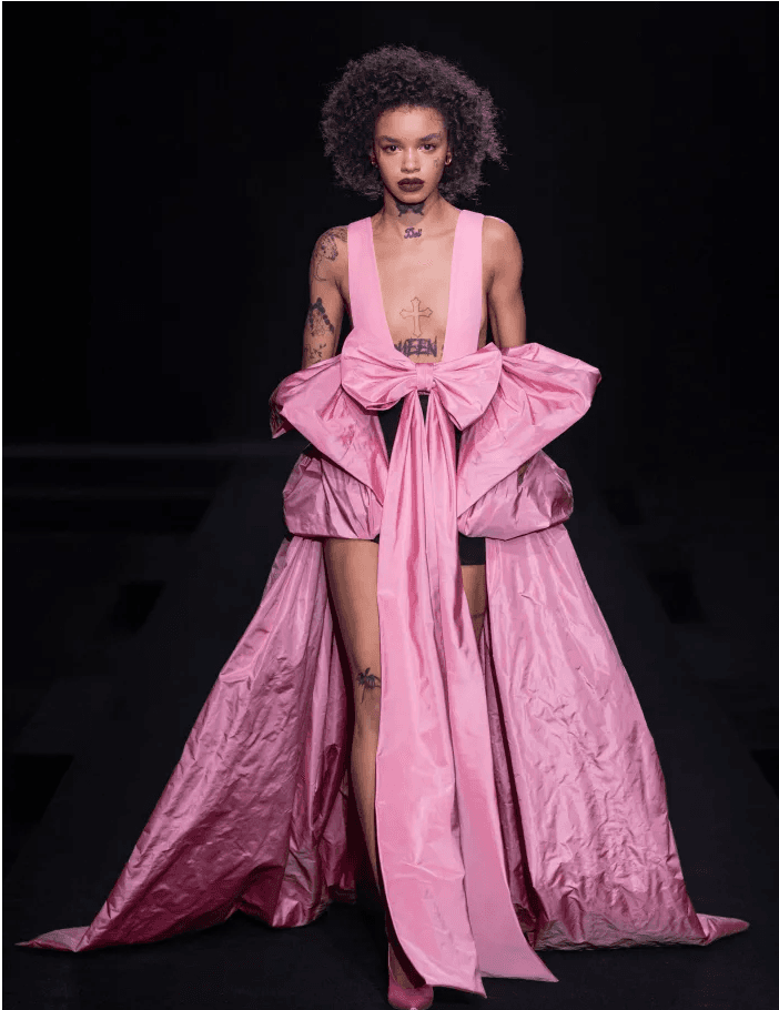 Podyumda pembe, gösterişli elbiseli ve kıvırcık saçlı model