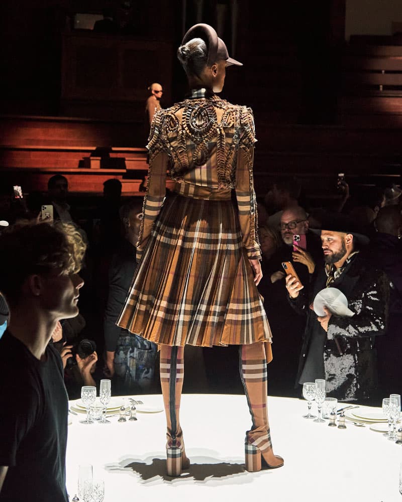 Burberry ekose desenli detaylı kıyafetli model podyumda arkadan