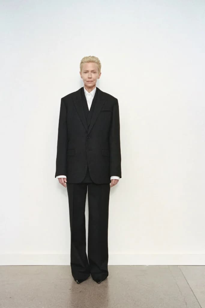 Tilda Swinton beyaz fon önünde bol kesim siyah takım elbiseli
