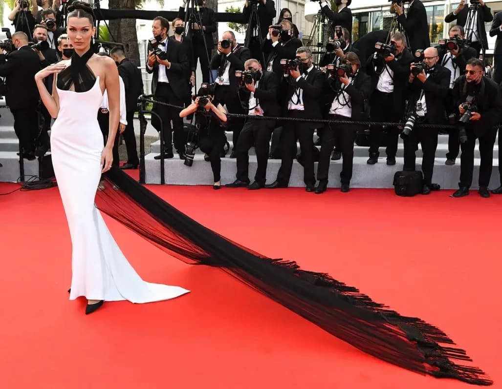 Bella Hadid kırmızı halıda beyaz elbise ve uzun siyah kuyrukla poz veriyor