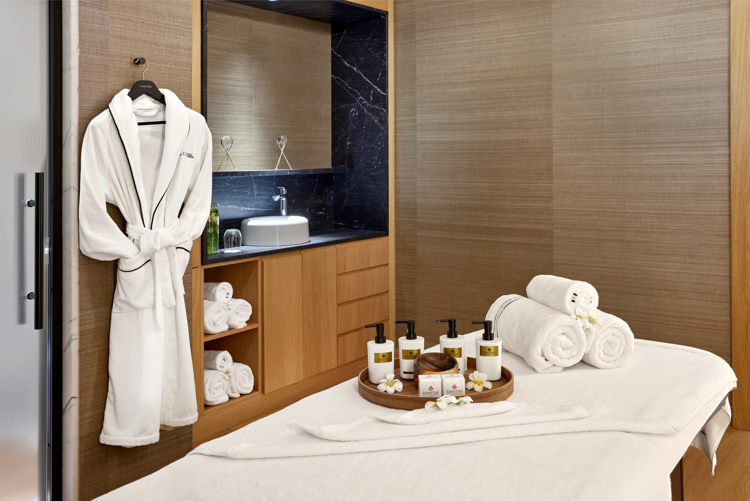 Şık spa odasında masaj yatağı bornoz havlular ve kozmetik ürünleri