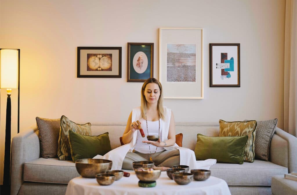 Ev ortamında ses kaseleriyle meditasyon yapan sakin bir kadın