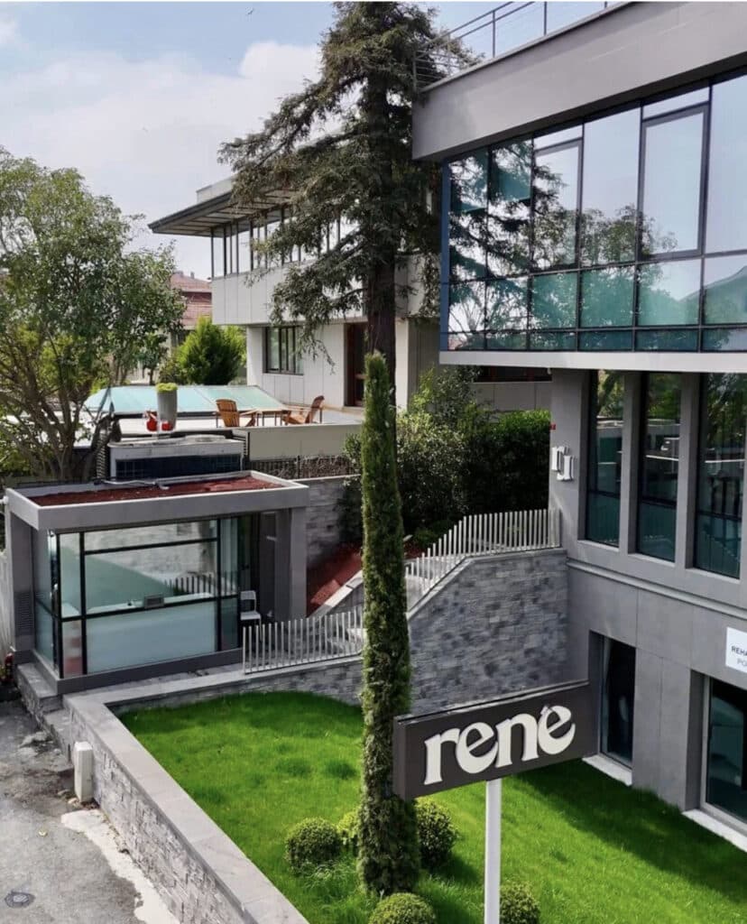 Modern bir bina, Rene tabelası, ağaçlar ve yeşil çim