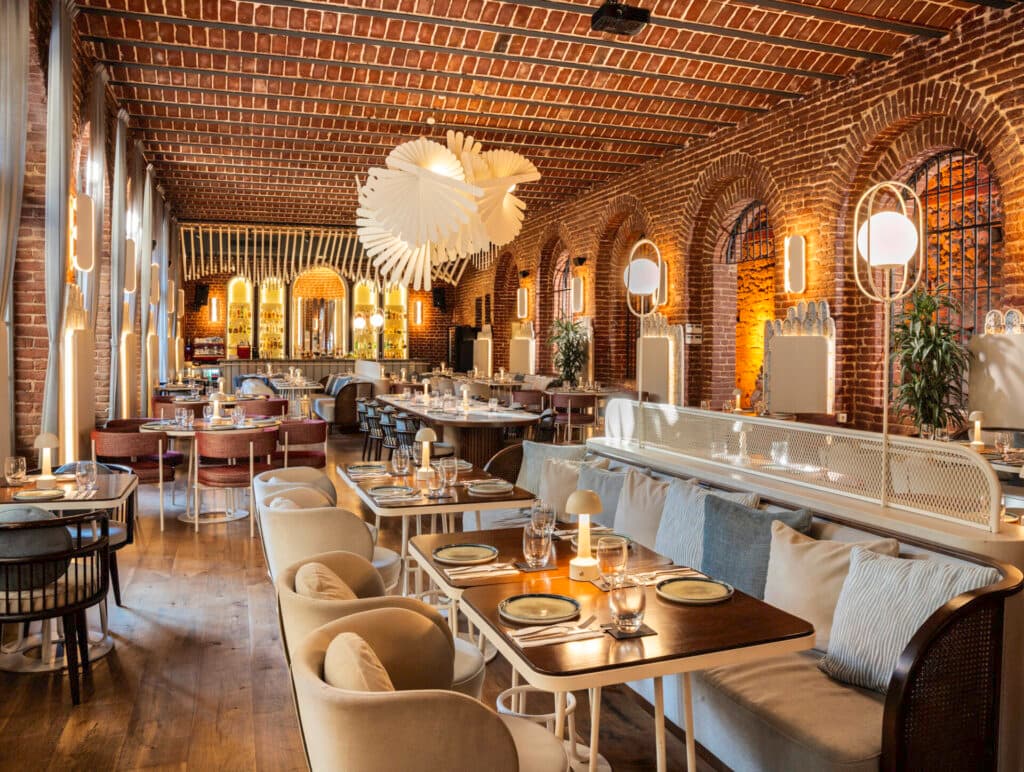 Tuğla duvarlı, kemerli ve şık aydınlatmalı modern restoran iç mekanı