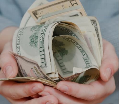 Avuçlarında bir tomar ABD doları olan eller