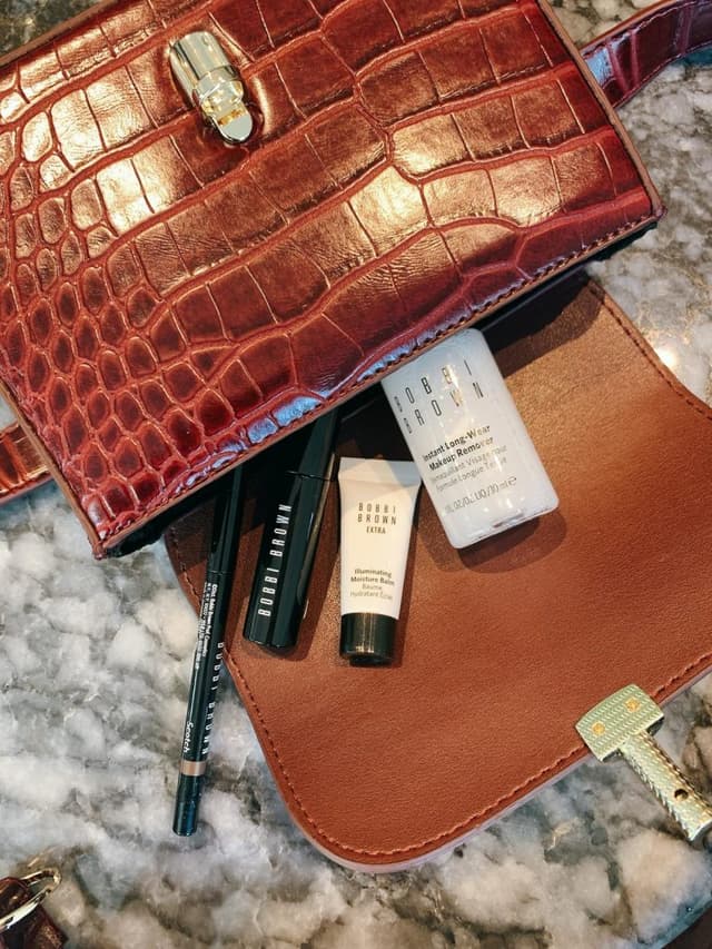 Bobbi Brown kozmetik ürünleri ve kahverengi timsah desenli şık çanta