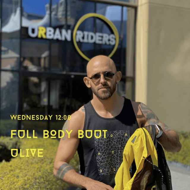Güneş gözlüklü adam Urban Riders önünde sarı ceket tutuyor metinle