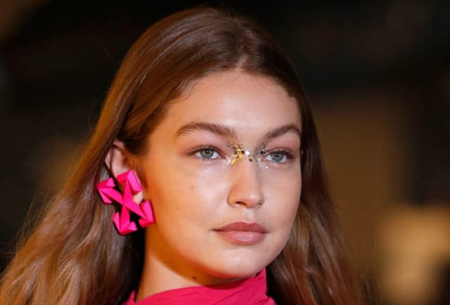 Gigi Hadid pembe küpeli, yüzünde parıltılı göz makyajıyla