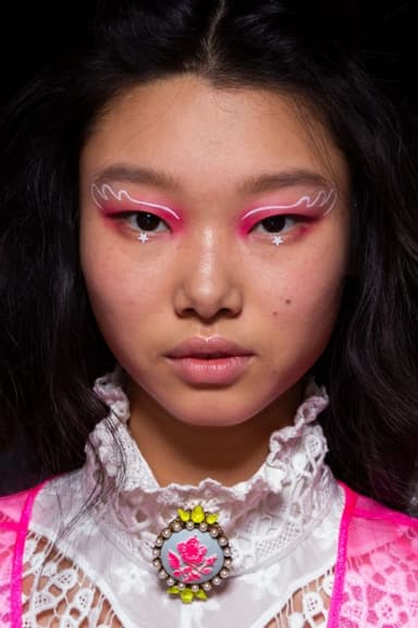 Pembe far, dalgalı eyeliner ve yıldızlarla genç kadının dikkat çekici makyajı