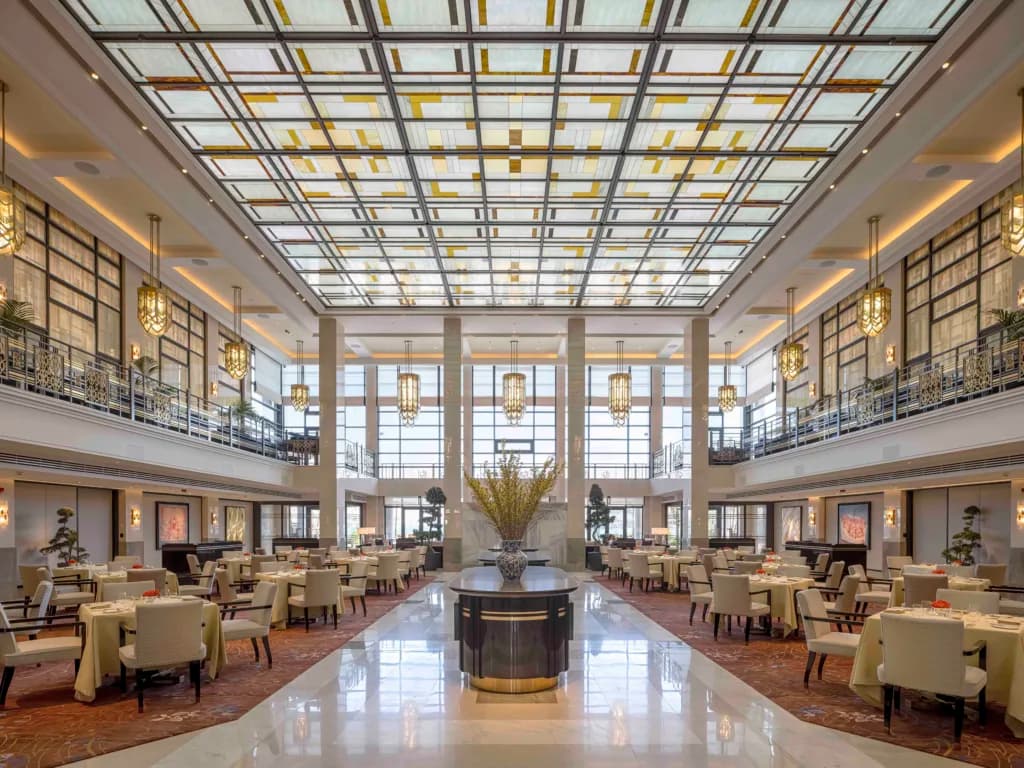 Lüks restoran salonu yüksek tavanlı vitray süslemeli şık masa düzeni
