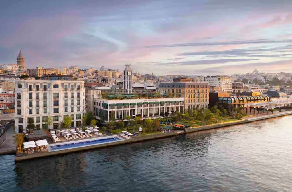 İstanbul'da deniz kenarında şehir manzarası, Galata Kulesi ve havuzlu otel