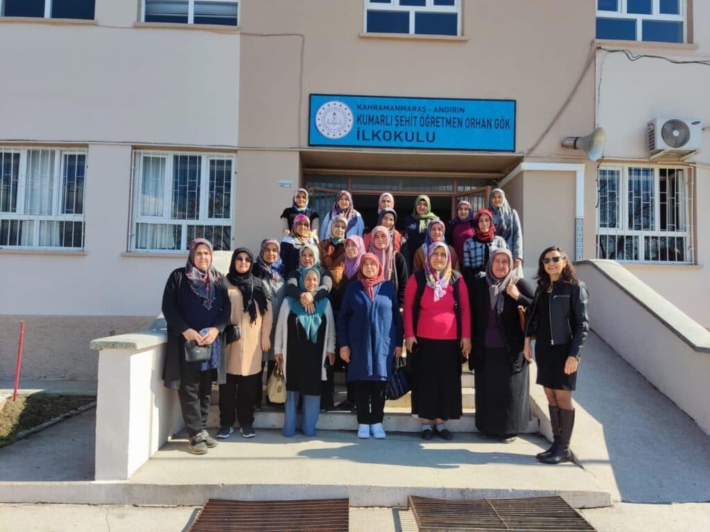 Okul binası önünde basamaklarda poz veren başörtülü kadınlar grubu