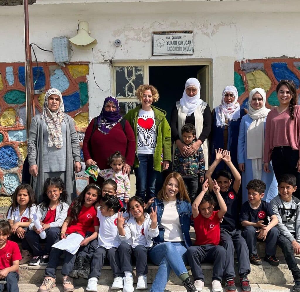 Köy okulunun önünde kadınlar ve çocuklar beraber poz veriyor