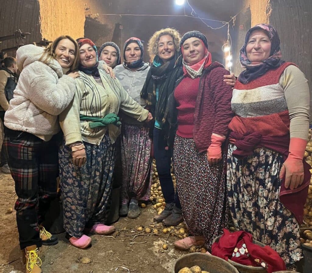 Patates mahzeninde geleneksel kıyafetli gülümseyen bir grup kadın
