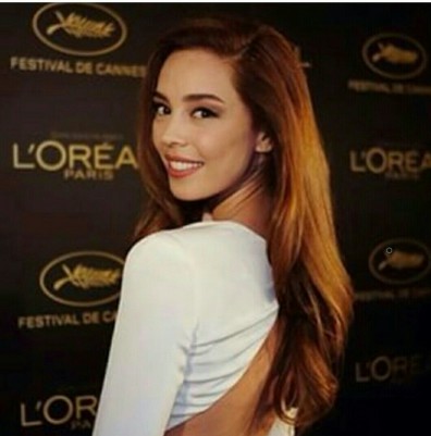 Uzun kahverengi saçlı, gülümseyen kadın L'Oreal Cannes etkinliğinde