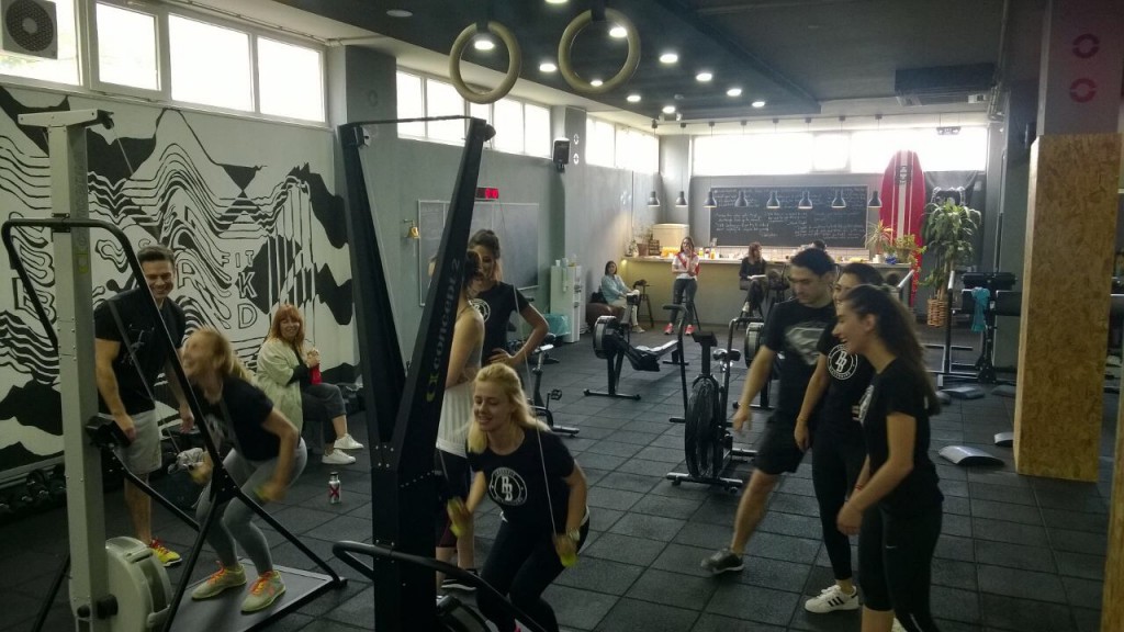 Spor salonunda egzersiz yapan ve sohbet eden mutlu bir grup insan