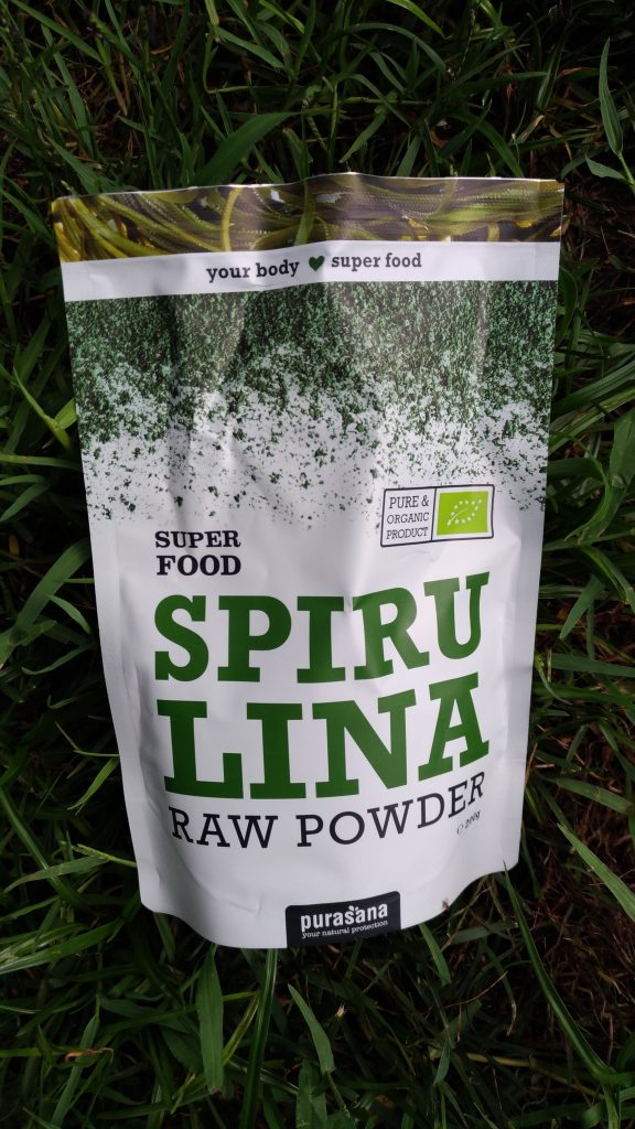 Çimler üzerinde Purasana spirulina ham tozu süper gıda paketi