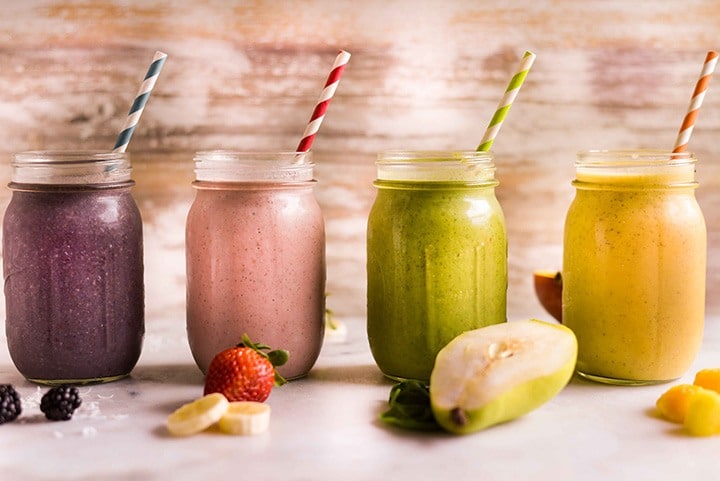 Sağlıklı meyveli smoothieler cam kavanozlarda ve taze meyveler