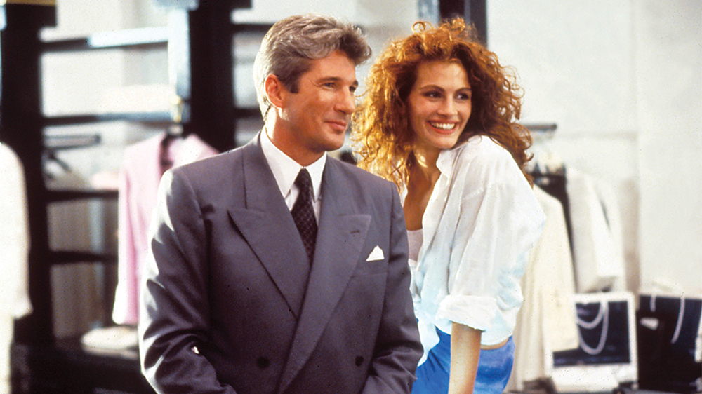 Richard Gere takım elbiseli Julia Roberts kıvırcık saçlarıyla neşeyle gülümsüyor