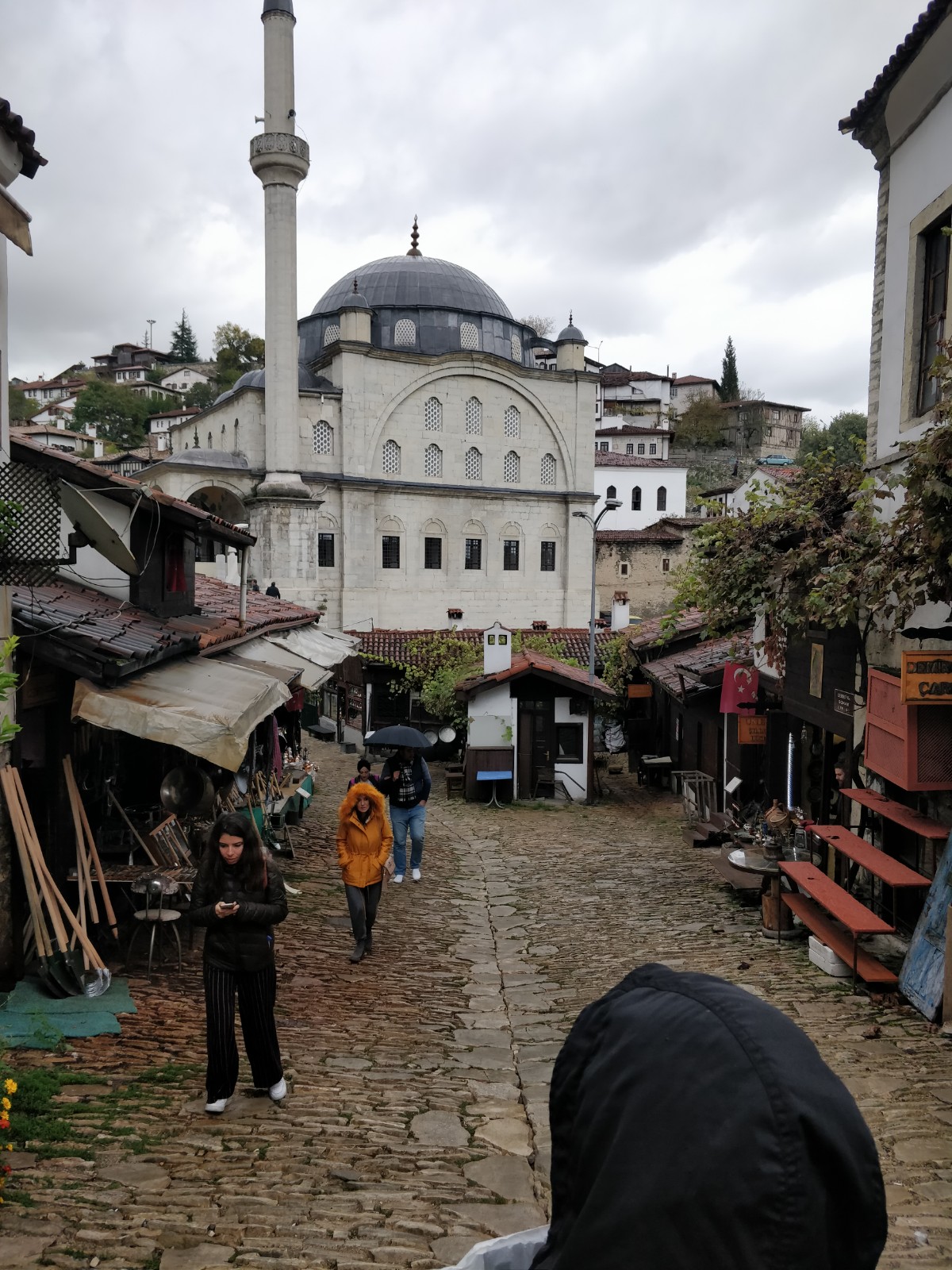 Geleneksel evler, cami ve insanlarla dolu eski bir sokak