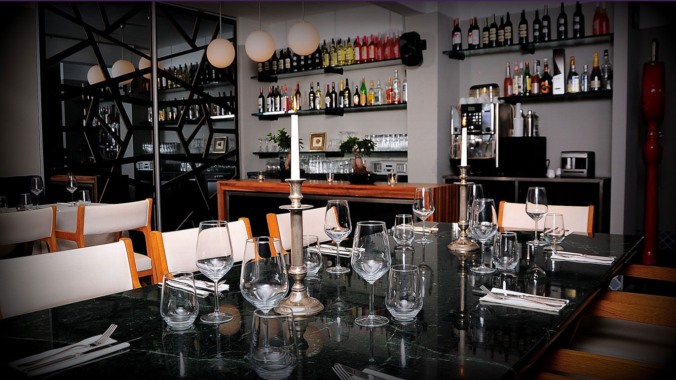 Şık bir restoranda kurulmuş masa, bar ve iç mekan detayları