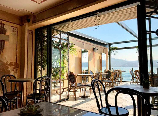 Deniz manzaralı şık bir kafe, içeride ve dışarıda oturma alanları