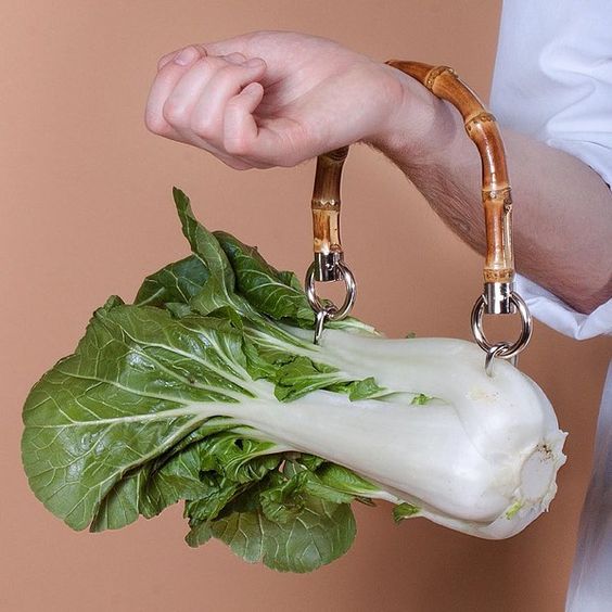 Bambu saplı bir pak choi çantayı kolunda taşıyan bir kişi