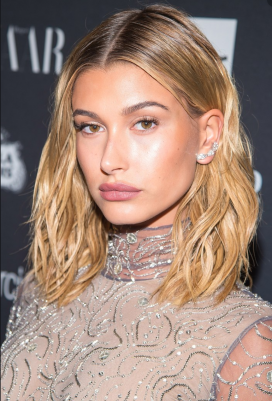 Hailey Bieber sarı ıslak saç doğal makyaj ve ışıltılı elbise giymiş