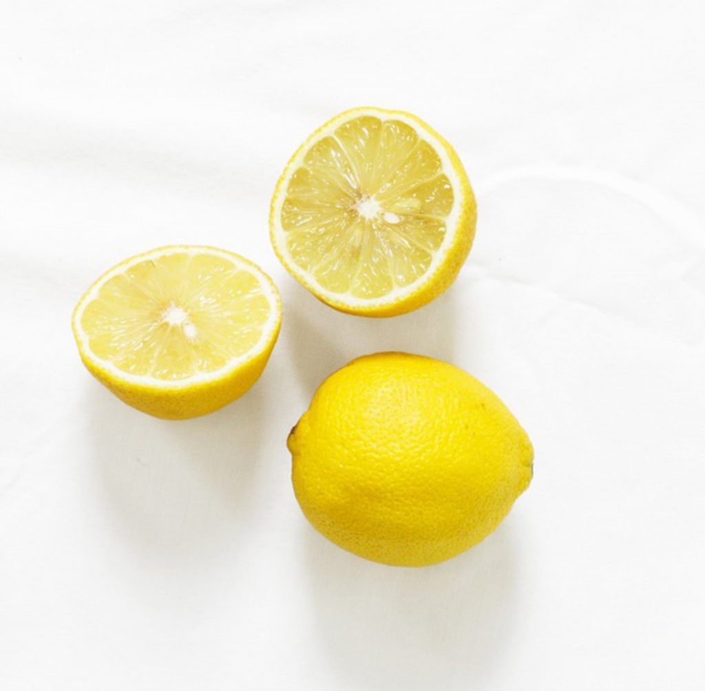 Beyaz zeminde ikiye kesilmiş ve bütün parlak sarı limonlar