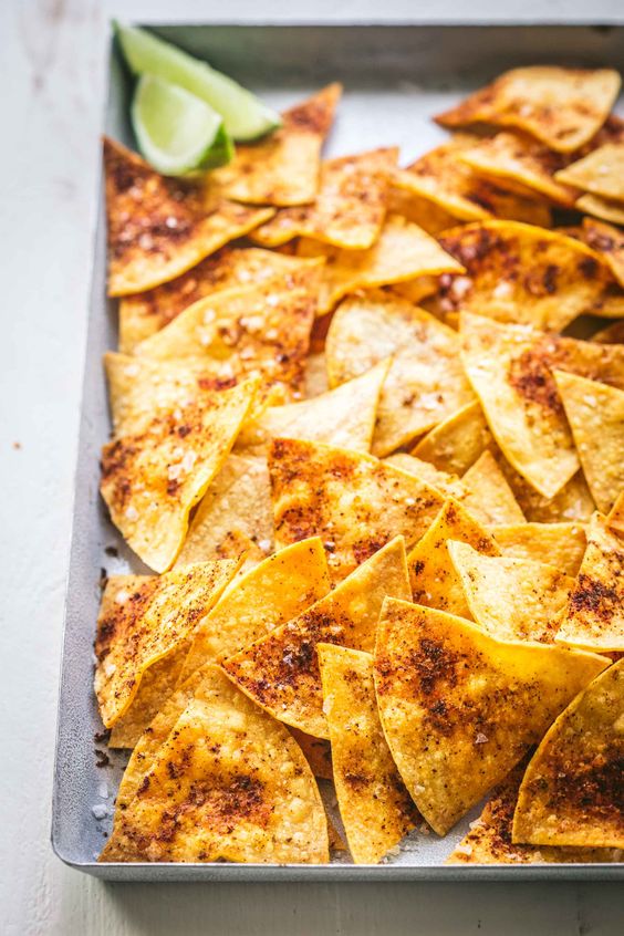 Baharatlı ve tuzlu tortilla cipsleri, yanında misket limonu dilimleri