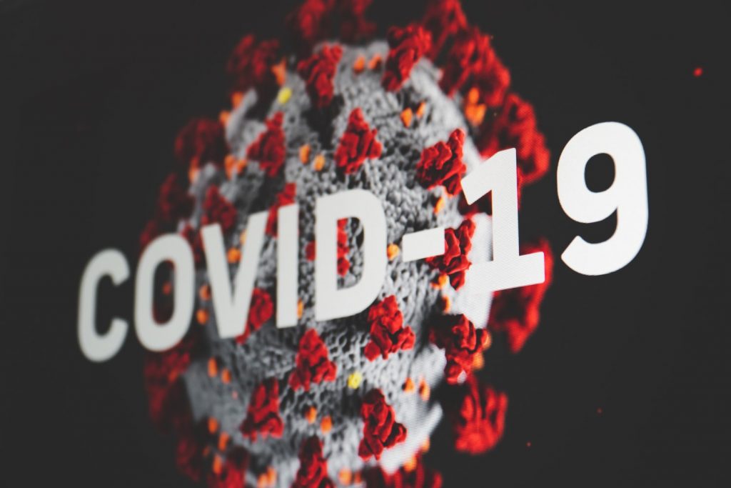 Koyu arka planda COVID-19 yazısı ve koronavirüsün 3D modeli