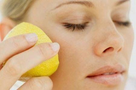 Bir kadın elinde limonla yüzüne doğal cilt bakımı yapıyor