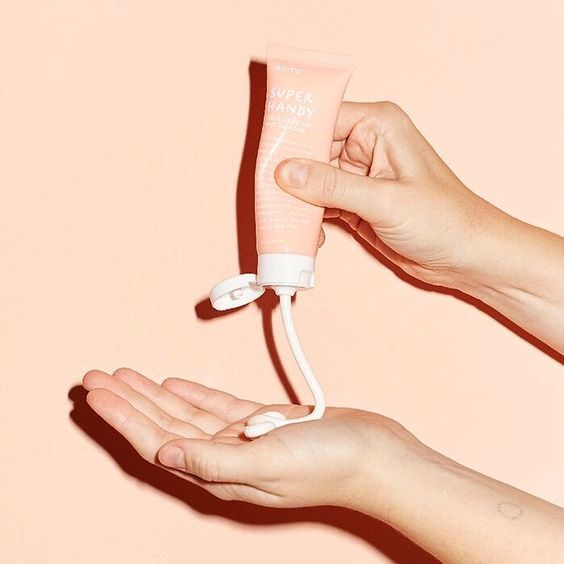 Pembe Super Handy tüpten eline krem sıkan eller