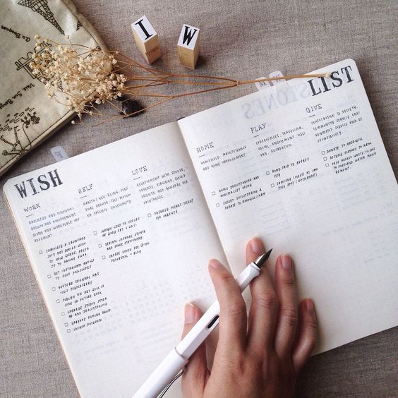 Bullet journalına dilek listesi kategorileri yazan bir el