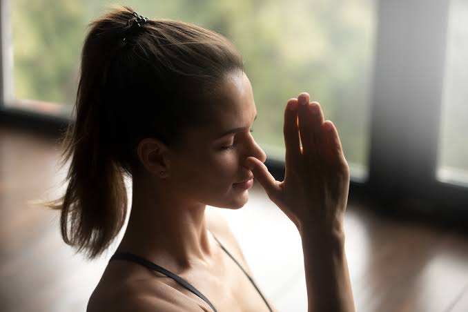 Gözleri kapalı sakin kadın meditasyon için nefes egzersizi yapıyor