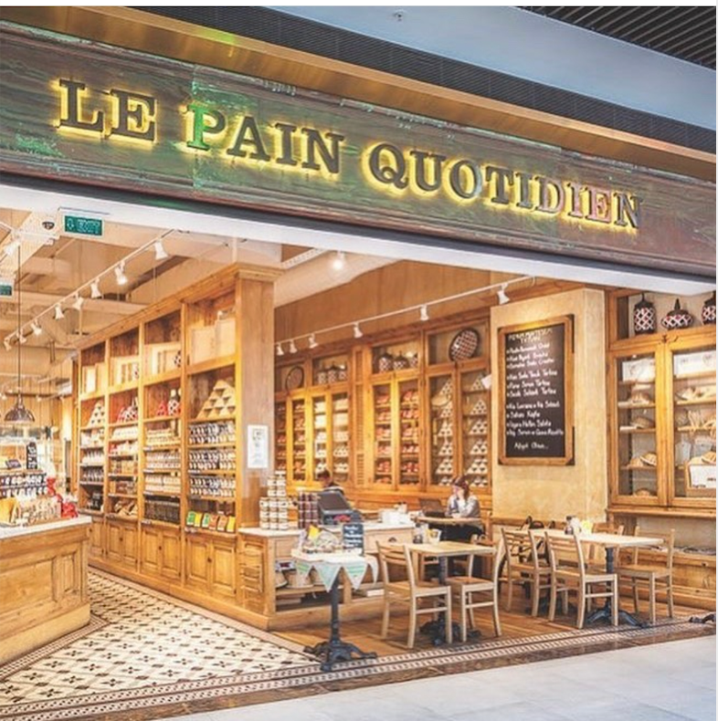 Ahşap dekorlu Le Pain Quotidien fırını, içeride oturma alanları ve ürünler