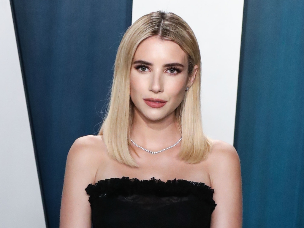 Emma Roberts sarışın saçları ve straplez siyah elbisesiyle objektife bakıyor