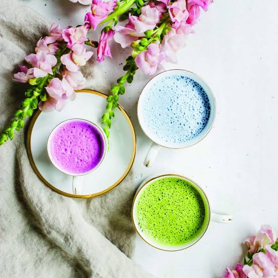 Renkli latte fincanları ve pembe çiçekler beyaz zeminde