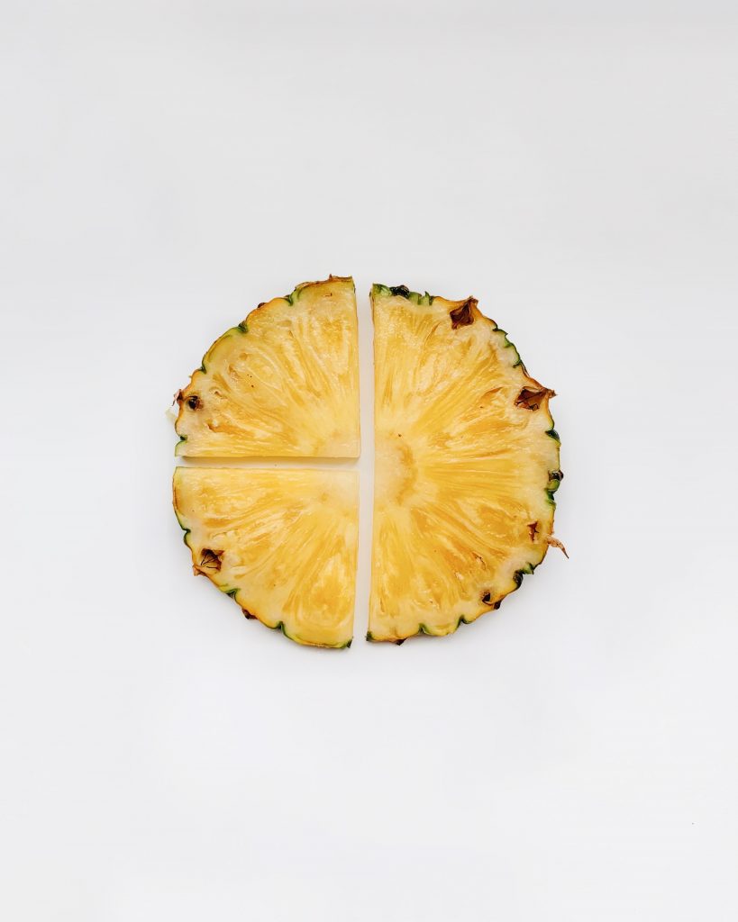 Beyaz zeminde dört parçaya ayrılmış yuvarlak ananas dilimi