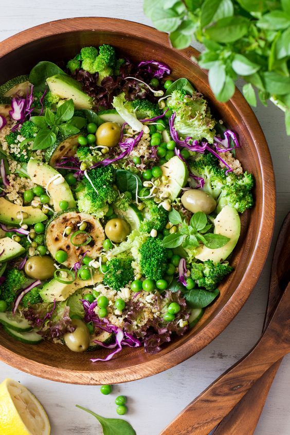 Ahşap kasede brokoli avokado bezelye ve kinoa içeren yeşil salata