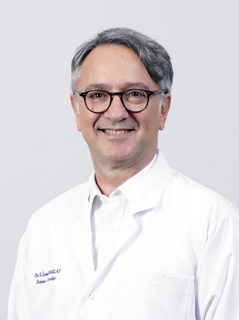 Beyaz önlüklü, gözlüklü, gülümseyen bir erkek doktorun yakın çekim portresi